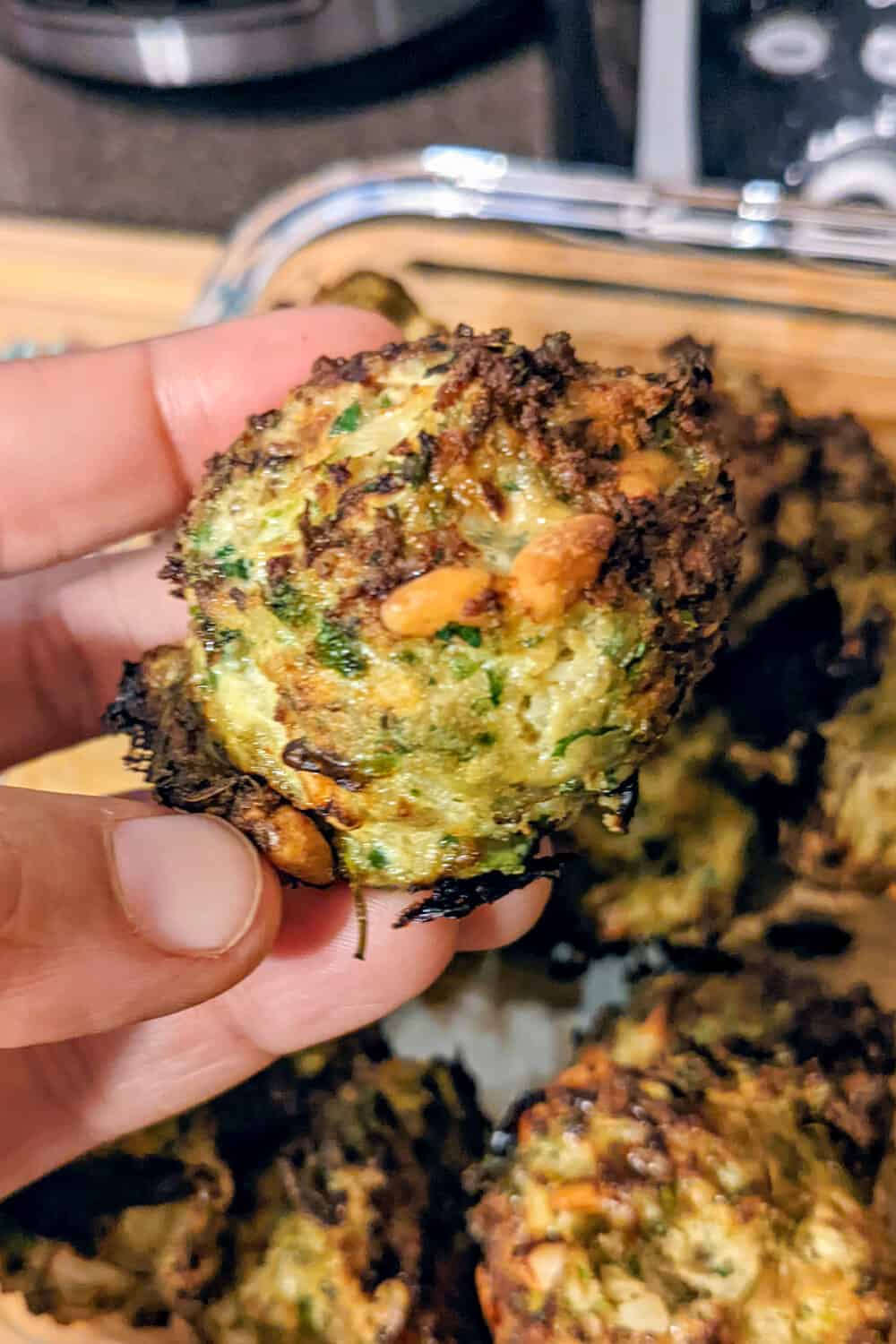 author's hand holding up a cooked turkey meatball